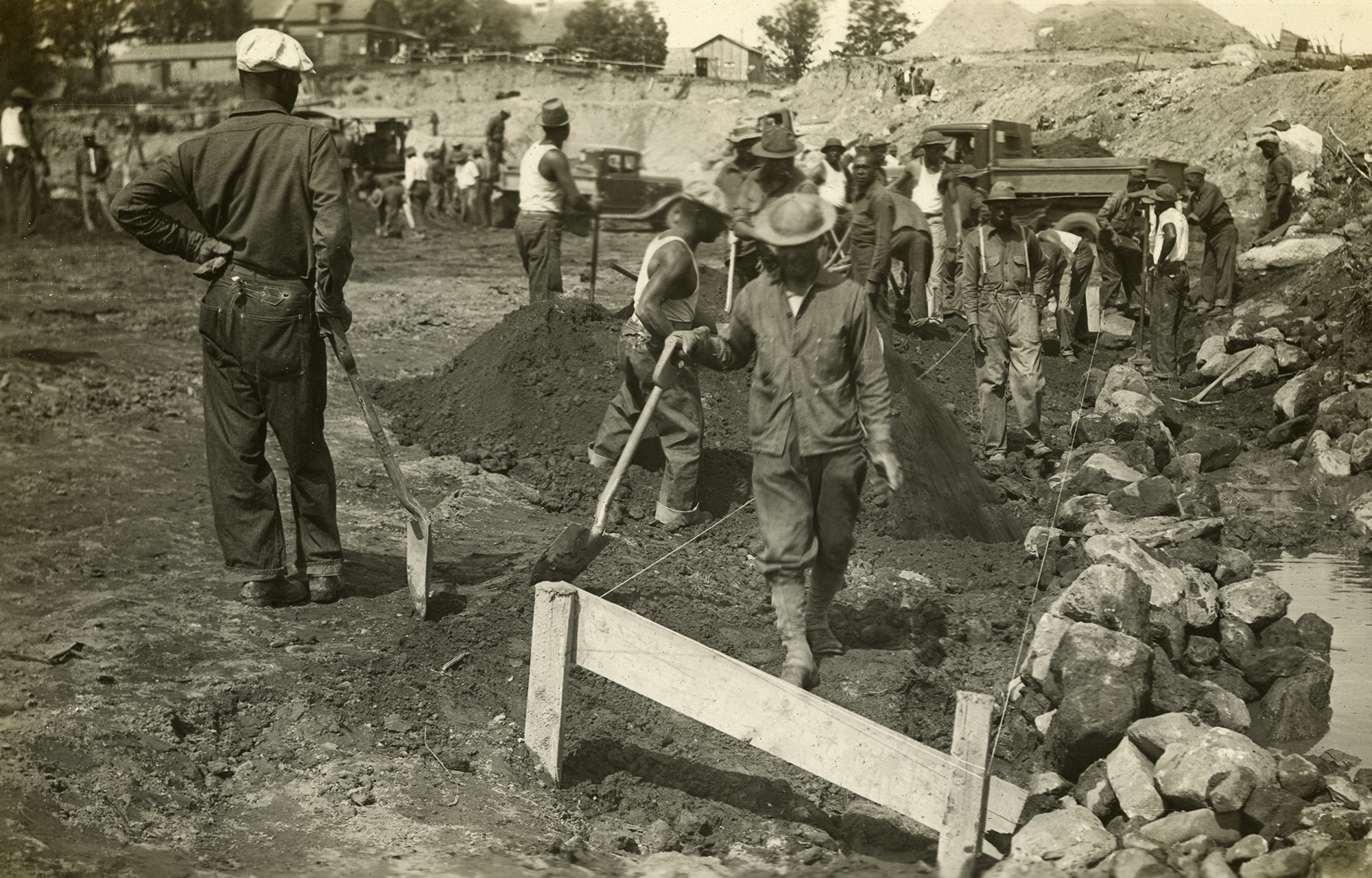 African American workers with hand tools excavate ground for dam African American workers with hand tools excavate ground for dam